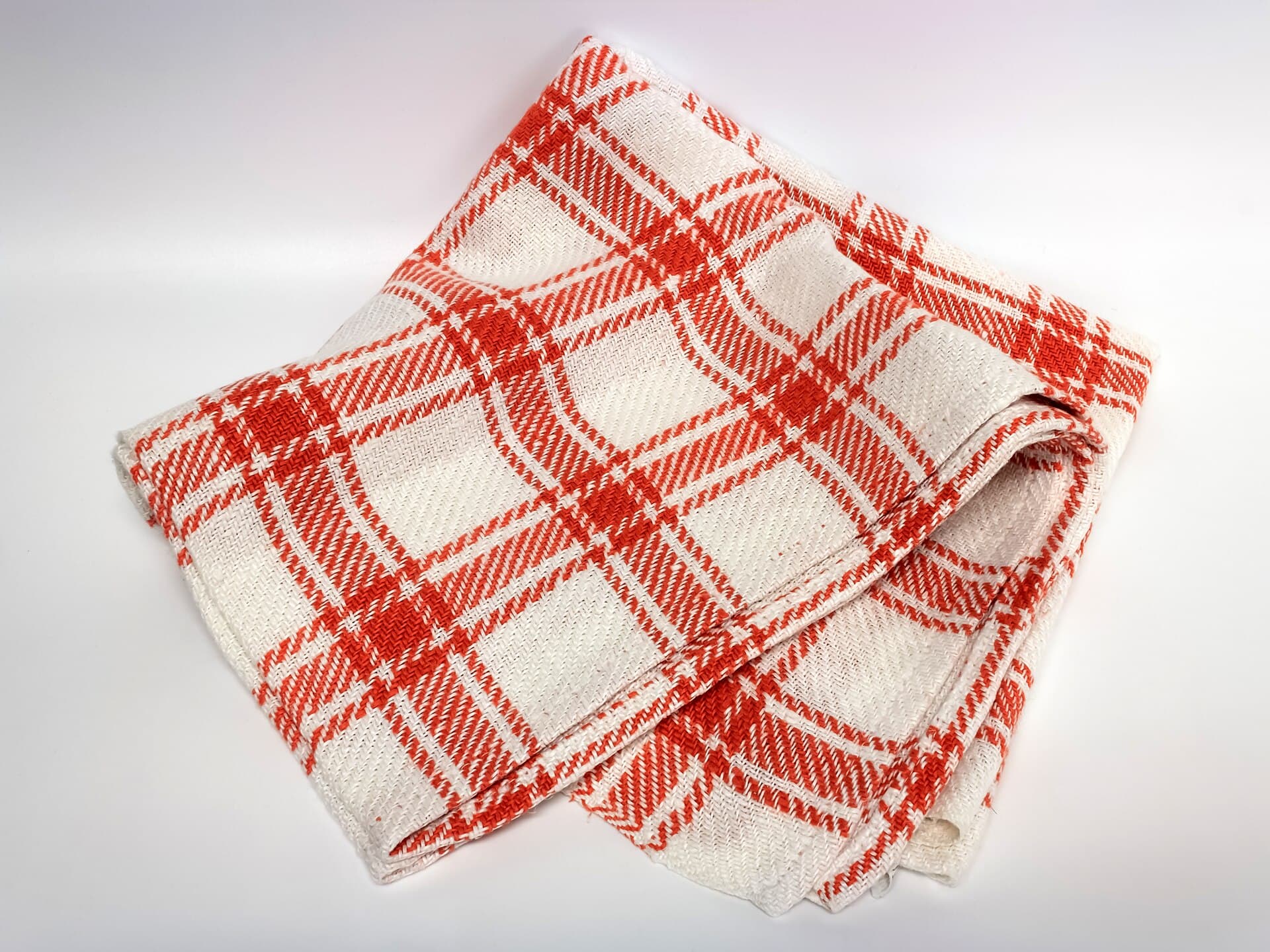 A cream linen cloth with a faint red check, photographed in soft light